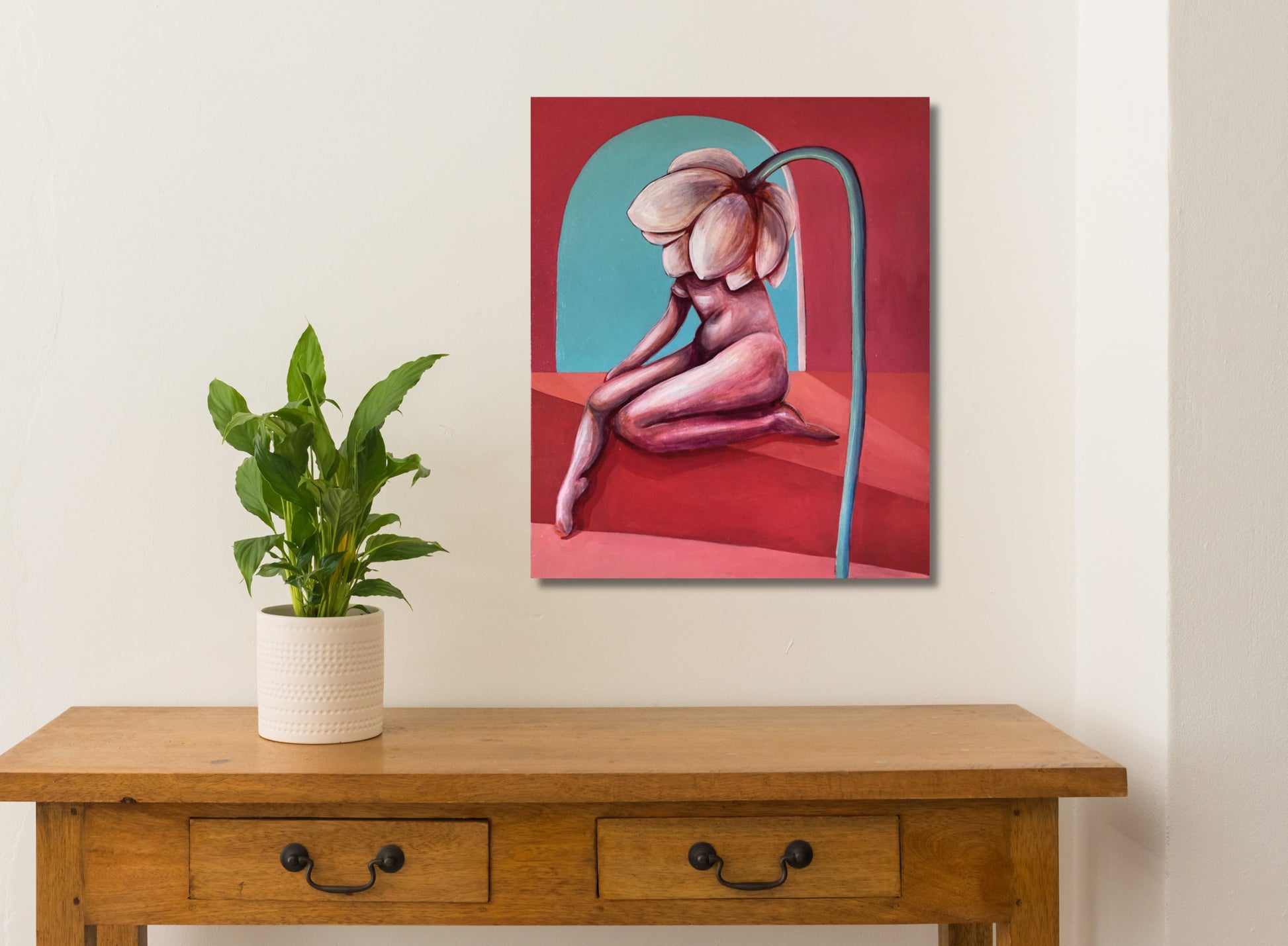 An oil painting on linen, depicting a nude figure with a large flower-like growth on the back, with a red and blue abstract background. white wall, table and plant