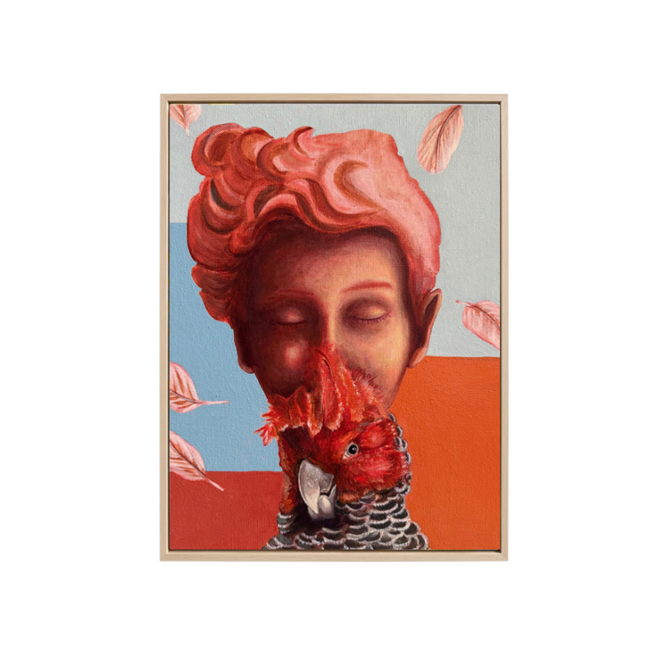 A framed surreal art print featuring a stylized face with pink hair merging into a gang gang cockatoo, set against a light gray background with pink leaves floating around.